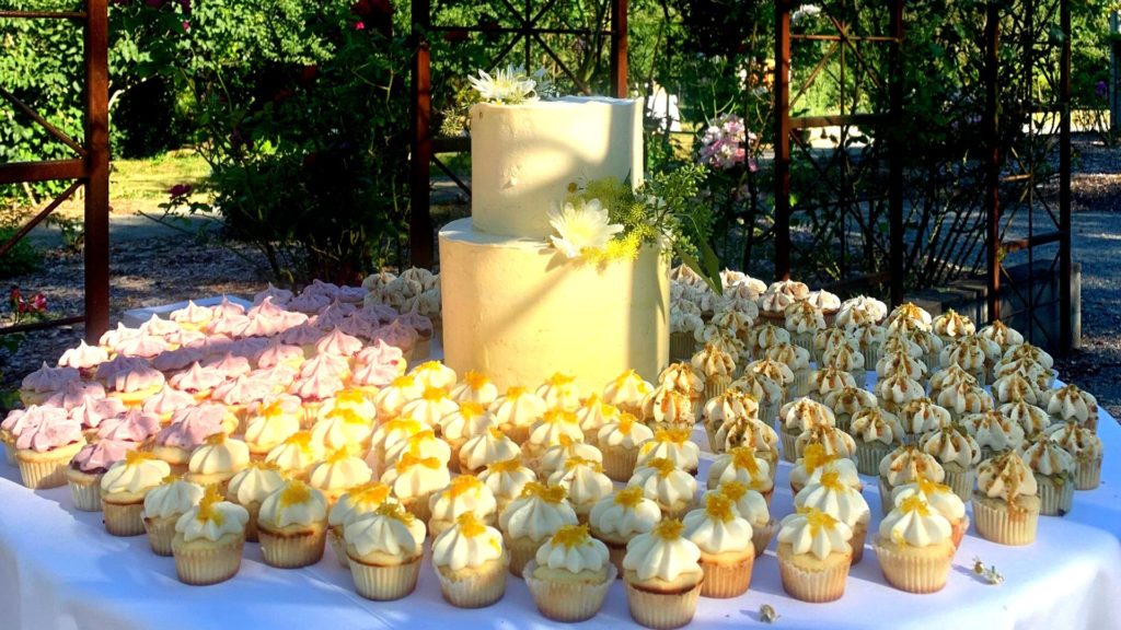 wedding cake and cupcakes on a table